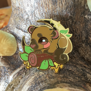 A hard enamel pin featuring the Kinkajou, alternatively called Honey Bear